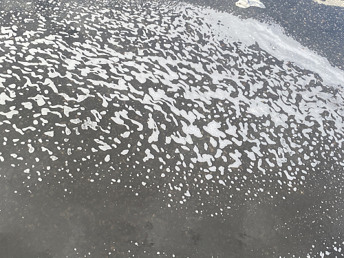 Белая пена на кольцевой автодороге в Санкт-Петербурге, образовавшаяся после дождя, не несет угрозы загрязнения Финского залива